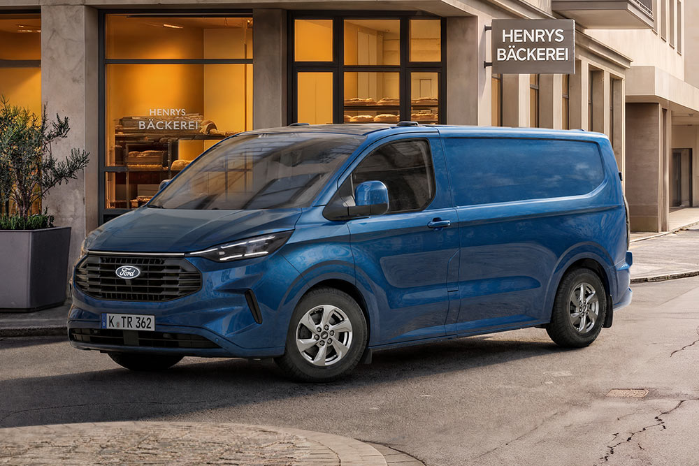 Ein blauer Ford Transit Custom Kastenwagen parkt vor einer Bäckerei.