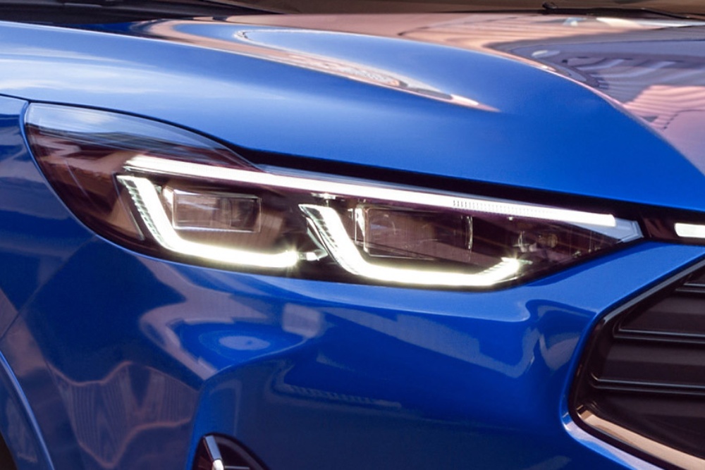 Nahaufnahme des vorderen Scheinwerfers eines blauen Ford Kuga.