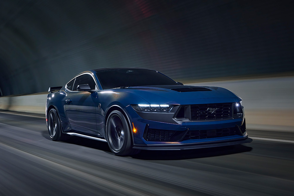 Ein dampfblauer Ford Mustang Sportwagen fährt durch einen Tunnel.