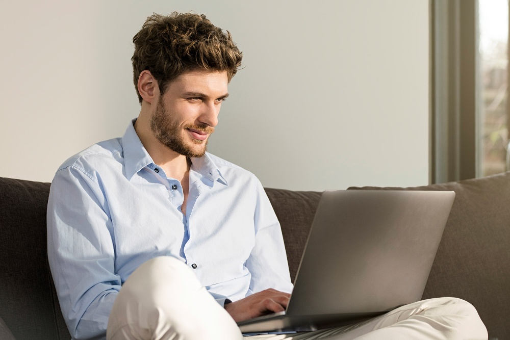 Mann, der auf seinem Laptop die Online Service Buchung von Ford nutzt