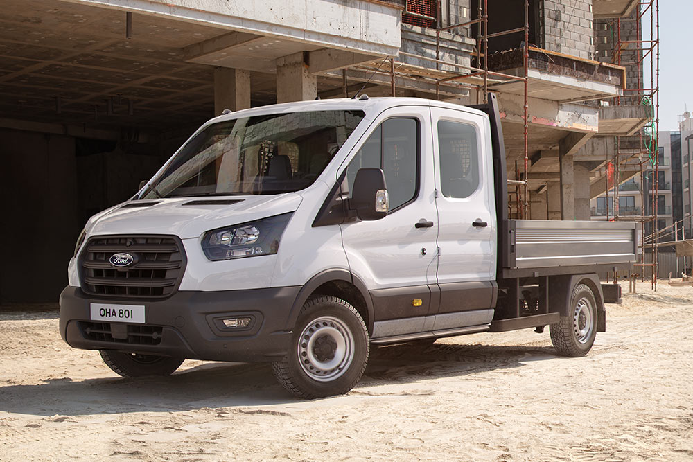 Weißes Ford Pro Fahrgestell parkt auf einer Baustelle neben zwei Bauarbeitern.