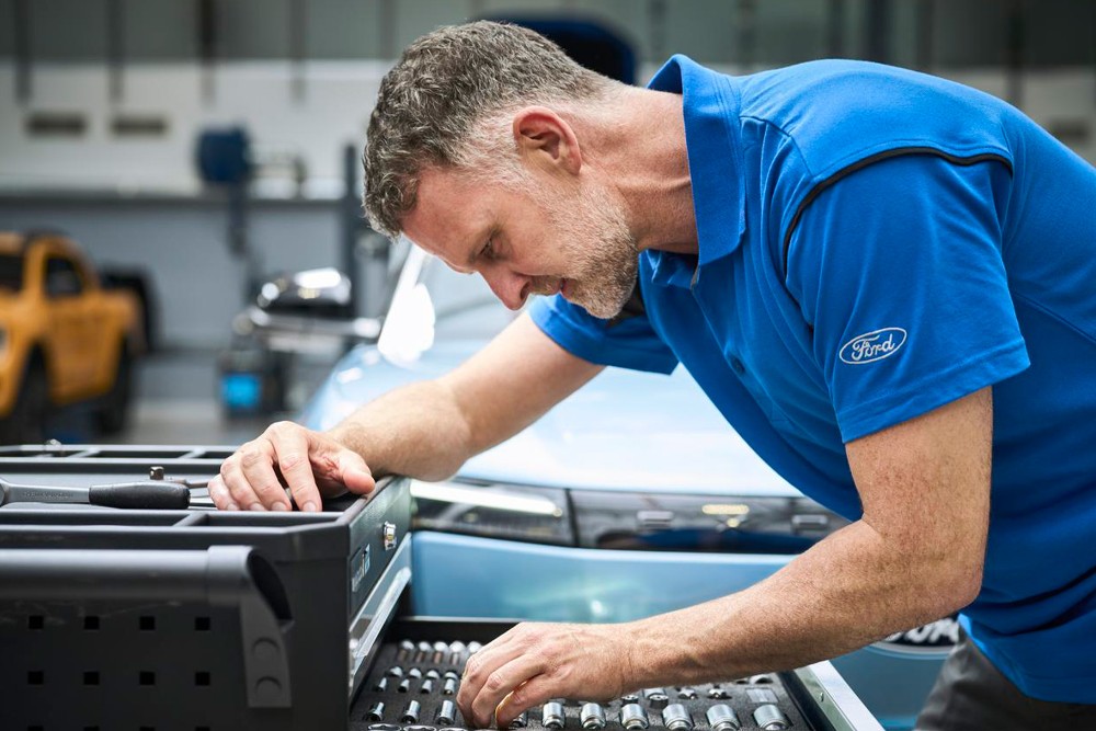 Mann überprüft Auto auf Klimaanlagenfunktionalität